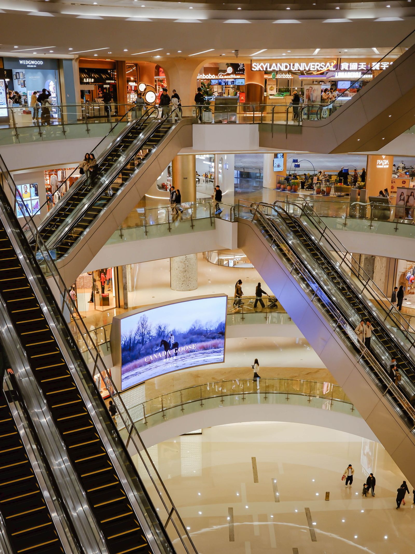Shoppers on escalators inside a shopping mall